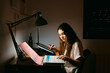 © Eloisa Ramos/Stocksy - Teen girl studying in her room at night