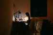 © Eloisa Ramos/Stocksy - Teenager girl texting sitting on her desk at night