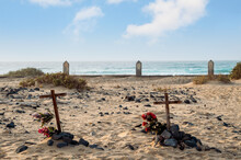 Tomb With Wooden Cross And Flowers In Beach