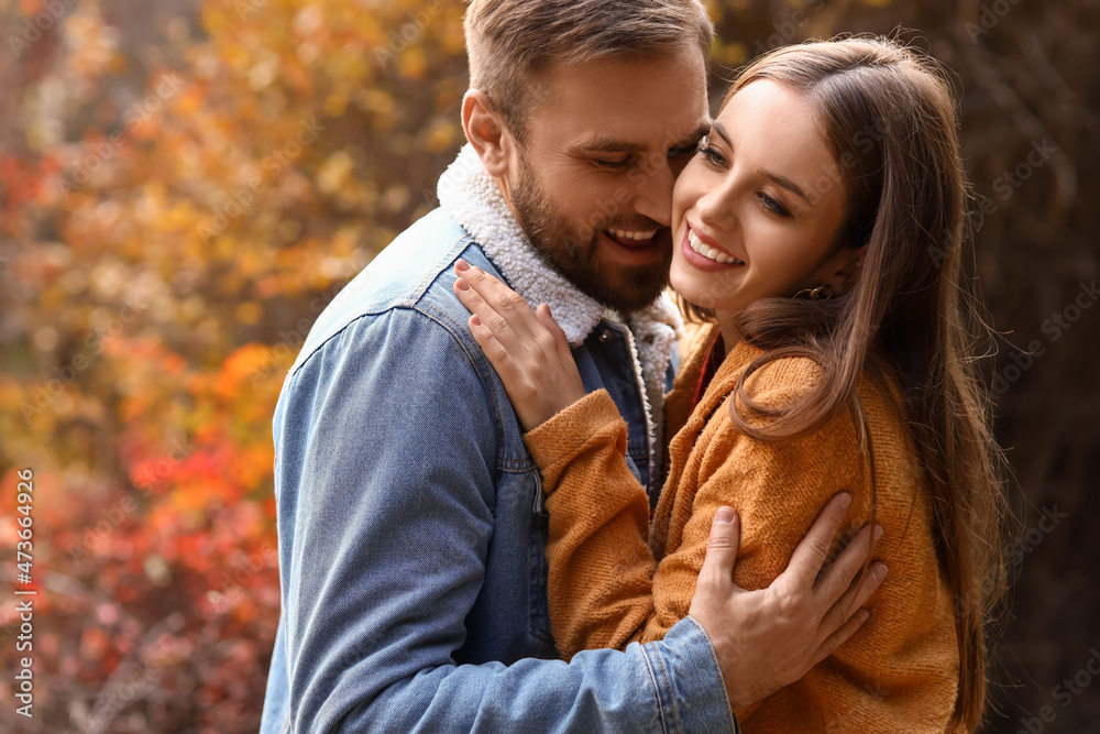 Beautiful young couple hugging in autumn park