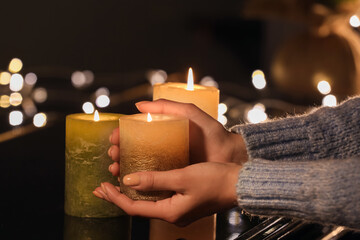 Wall Mural - Woman with burning candles on piano, closeup