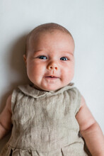 Blue-eyed Baby Girl In Linen Romper