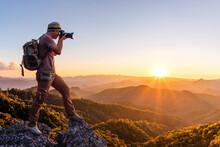 Professional Nature Professional Nature Photographer Taking Photos On Top Mountains Sunset Background. Nature Photography Concept.