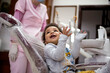 © Jelena Markovic/Stocksy - Toddler sitting in dentists chair