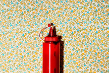 Dirty Ketchup Squeeze Bottle On A Floral Background
