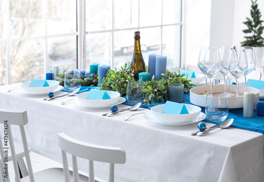 Dining table with beautiful setting for Christmas celebration and blank cards in room