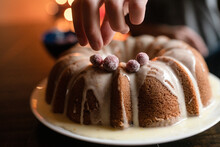 Hand Decorates Bundt Cake With Sugared Cranberries