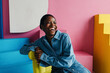 © Sergey Filimonov/Stocksy - Happy black woman portrait in colorful interior