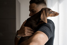 Man Embracing His Dog At Home