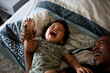 © Jelena Markovic/Stocksy - Happy toddler laying on the bed
