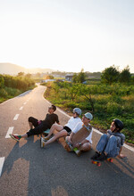 A Group Of Asian Friends Are Skateboarding