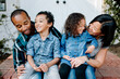© Erin Brant/Stocksy - Happy mixed race family sitting on porch
