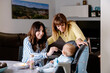 © Albert Martinez/Stocksy - A lesbian couple feeding their baby at home