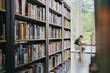 © Heng Yu/Stocksy - A man sitting and reading in library