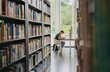 © Heng Yu/Stocksy - A man sitting and reading in library