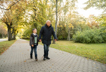 Grandad And Grandson Walking Outdoors