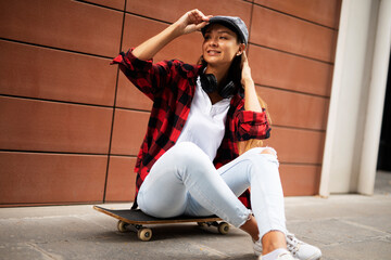 Wall Mural - Fashion urban woman with skateboard. Young happy girl enjoy outside.