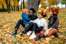 Diverse Family Trying On Wreath Of Yellow Leaves