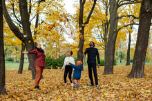 Multiracial Family Throwing Withered Leaves