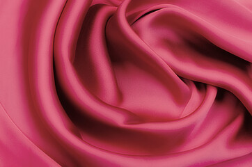 Close-up texture of natural red or pink fabric or cloth in same color. Fabric texture of natural cotton, silk or wool, or linen textile material. Red canvas background.