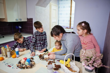 Mother with four kids makes a wreath for Christmas Eve and crafting decorating. New Year celebration.