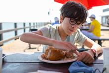 Boy Eating Clam Chowder On Bread At The Port
