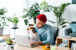 © Studio Marmellata/Stocksy - Focused man with dog using laptop