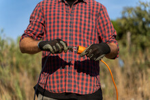 Detail of Man plugging a cable into outlet outdoors
