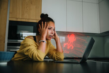 Woman With Head In Hands Looking At Danger Icon Laptop