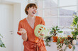 © Westend61 - Cheerful woman holding decor at home during Easter