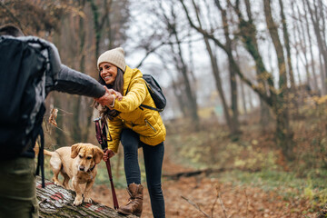 Joyful caucasian woman, crossing over a tree, during hike, with