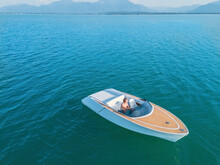 Germany, Bavaria, Aerial View Of Shirtless Man Sitting In Motorboat Floating InChiemseelake