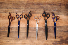 Various scissors on wooden table