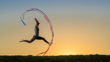 Sportswoman Doing Aerobics With Ribbons During Sunset