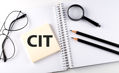 Poster - Word CIT on the sicker on notebook with pencils,magnifier and glasses