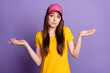 Photo of young clueless doubtful young woman shrug shoulders wear cap isolated on purple color background