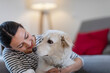 © Westend61 - Young female owner embracing cute dog at home
