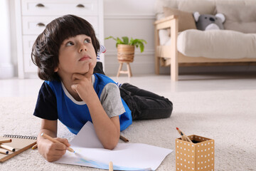 Sticker - Cute little boy drawing with pencils on floor at home