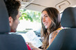 © Westend61 - Smiling girlfriend with map talking to boyfriend in car
