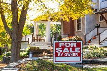 House For Sale Sign In Front Of Residence In Autumn