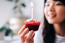 Woman Holding Cupcake With Candle At Home
