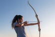 © Westend61 - Woman practicing archery by clear sky