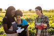 © Westend61 - Mother and daughter discussing over digital tablet while standing by female colleague at farm