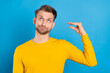 Photo of young man annoyed bored mocking show hands talk speak sign look empty space isolated over blue color background