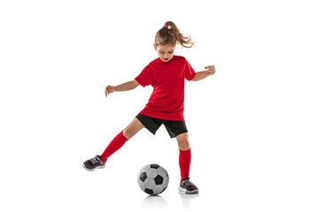 Wall Mural - Full-lenght portrait of little sportive girl in red uniform playing football team game isolated over white background
