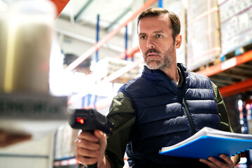 Close up of caucasian man using bar code reader in a warehouse