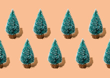 Studio Shot Of Rows Of Coniferous Trees Standing Against Beige Background