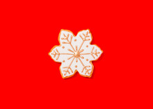 Snowflake Shaped Christmas Cookie Against Vibrant Red Background