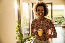 Happy Woman Holding Coffee Cup At Home