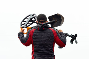 Wall Mural - a man with a metal detector and a shovel, view from the back